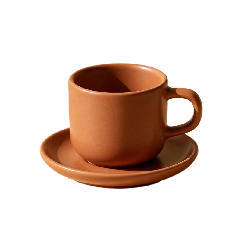 A terracotta cup and saucer with the background removed, shown on a transparency grid